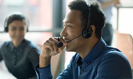 a man helping a customer on the phone with a smile